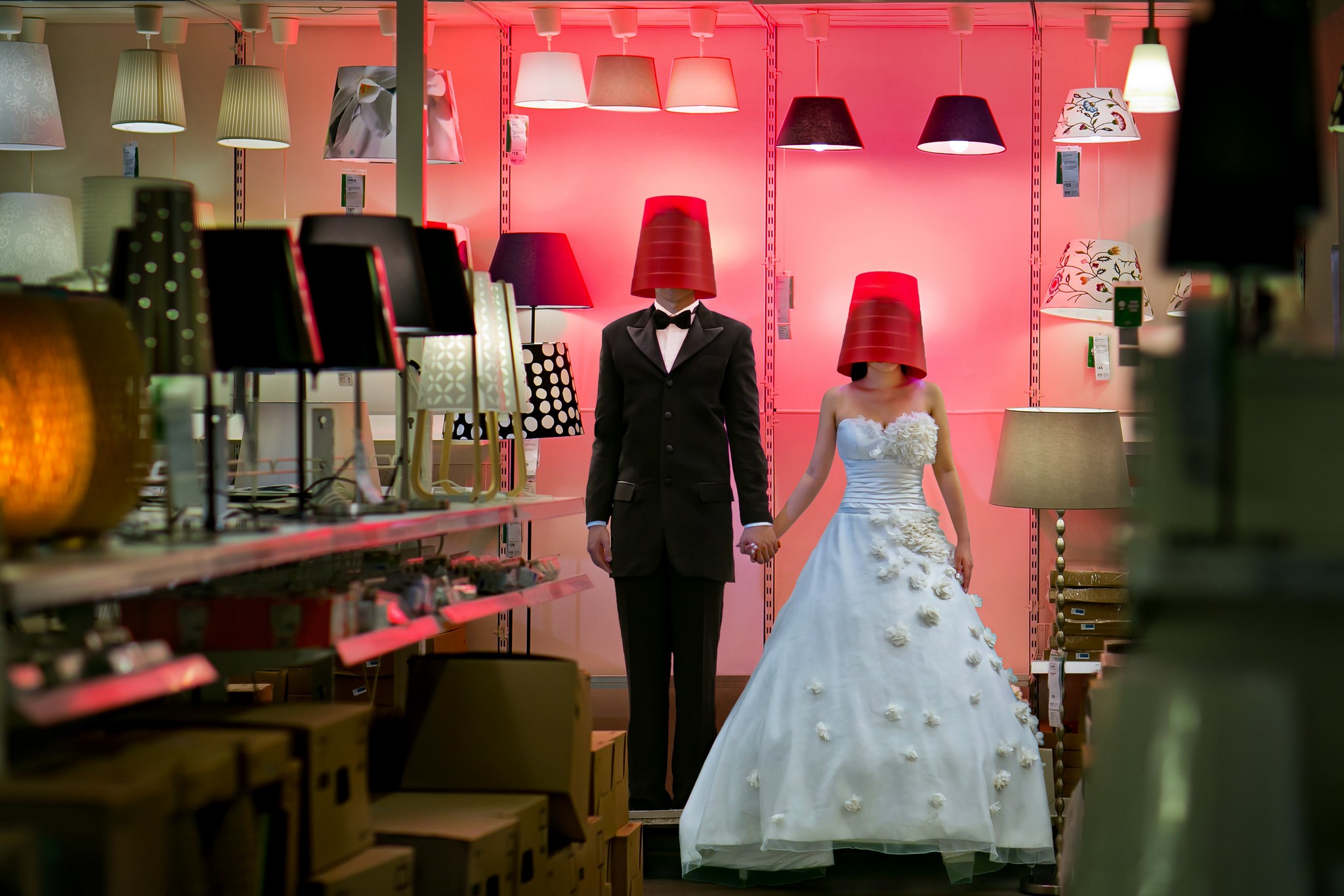 Creative photography by Raymond Phang featuring a couple in red hats inside a store.