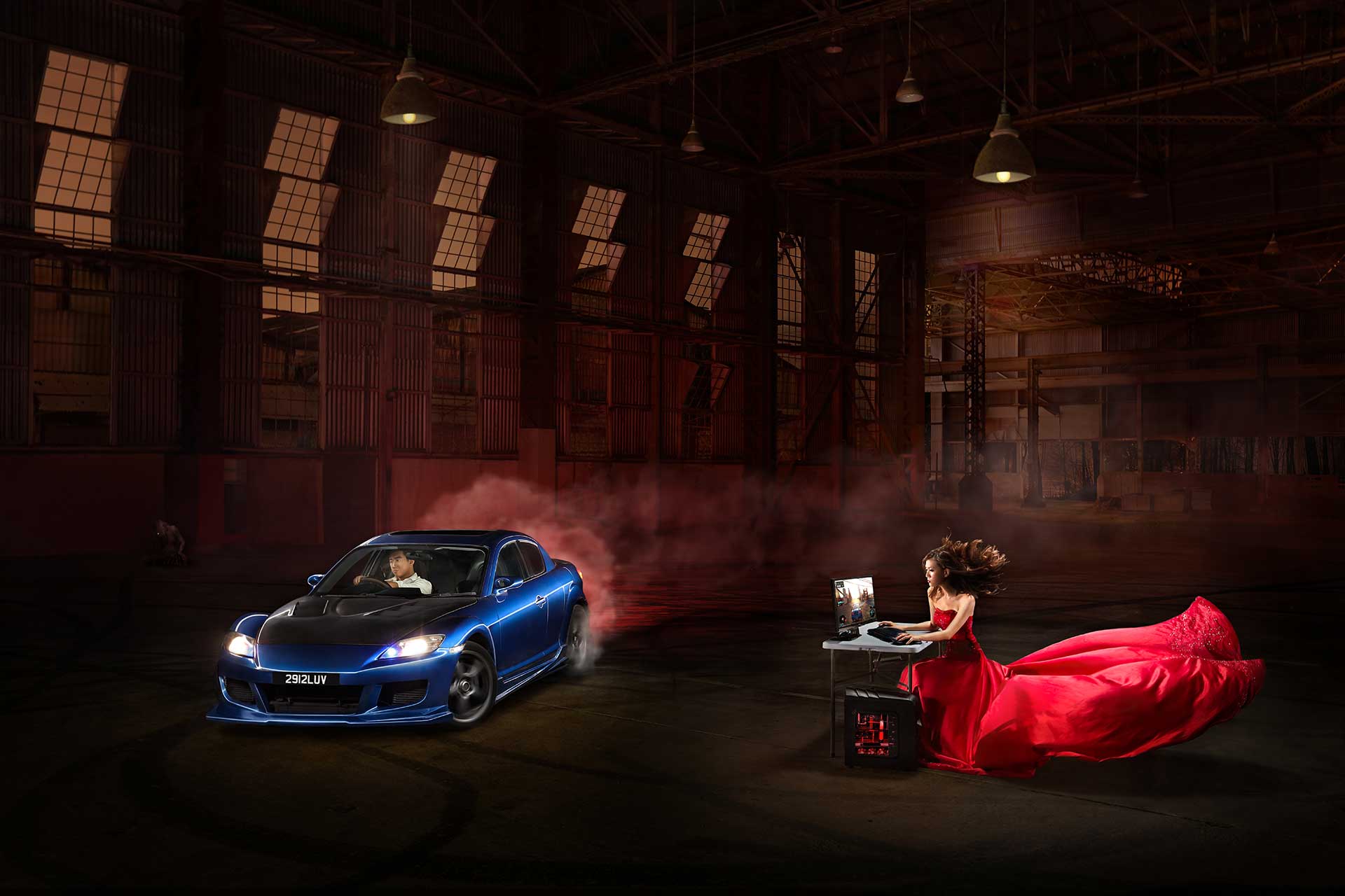 A woman in a red dress sits gracefully beside a car during a couples' creative pre-wedding photoshoot.