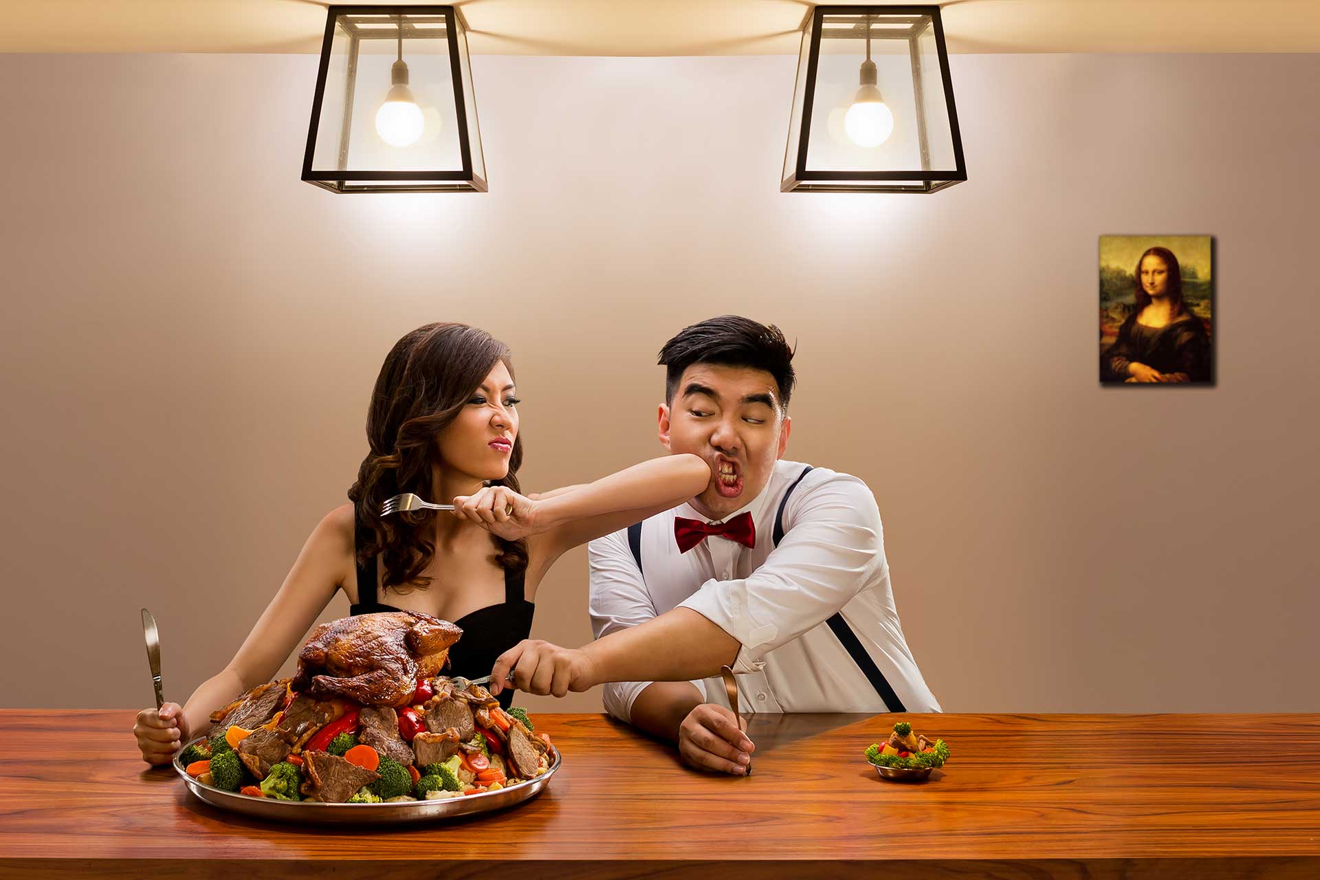 creative pre wedding photography: A couple engages in a humorous battle over a meal