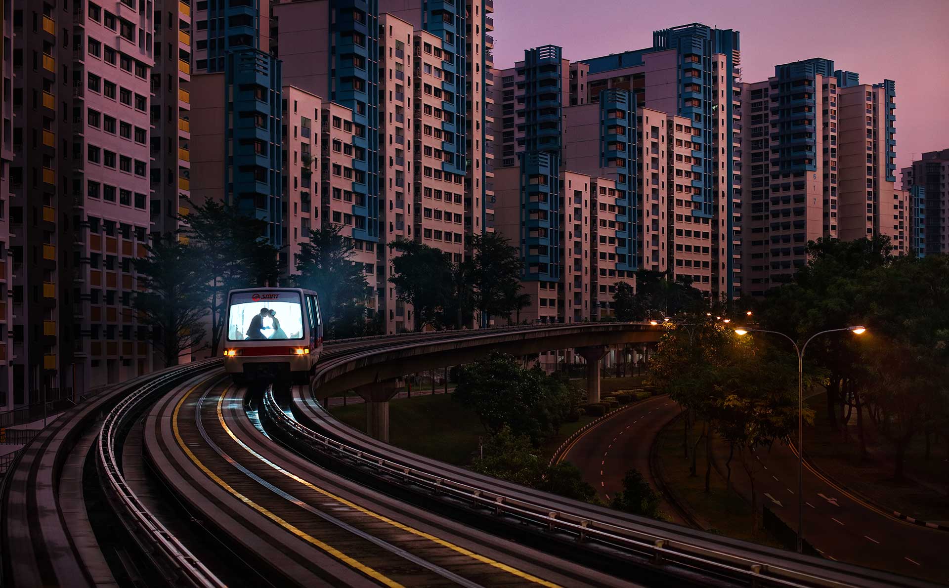 A train passing by tall buildings, with couples inside for creative pre-wedding photography