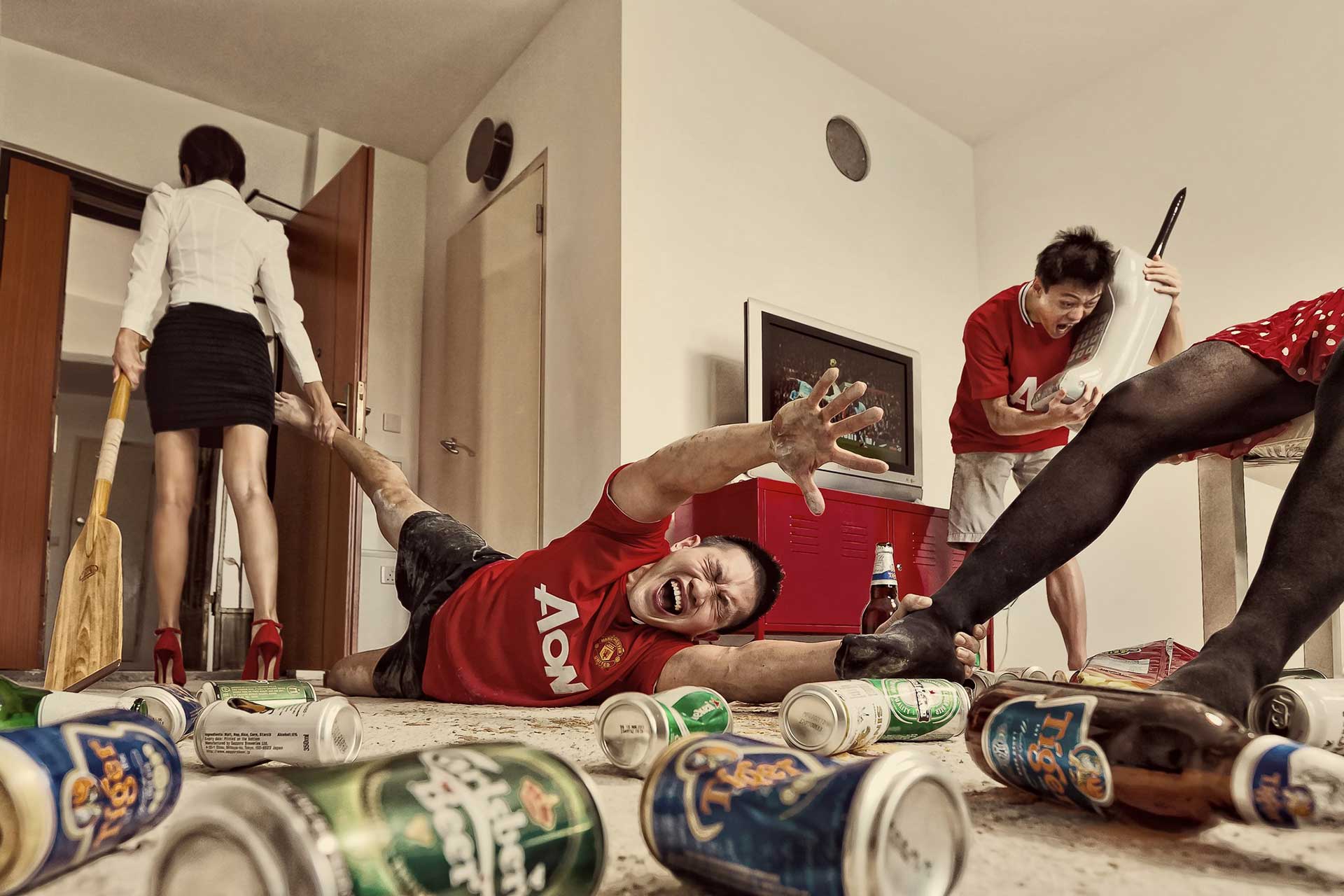 Man lying on floor surrounded by beer cans, part of creative pre-wedding photography with humorous moments.